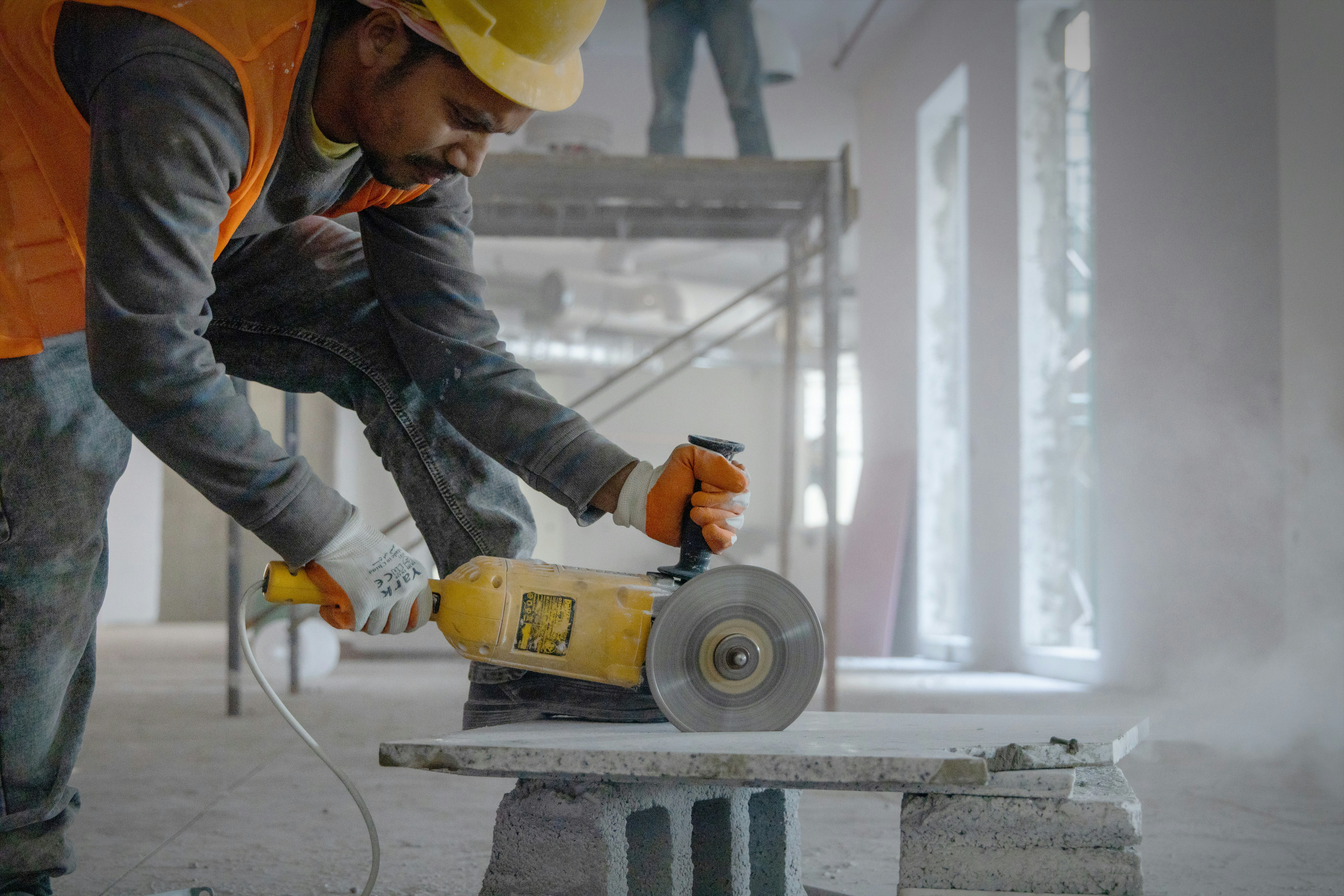 Construction worker using power tools on a job site — the kind of noise-exposed worker that hearing conservation programs protect